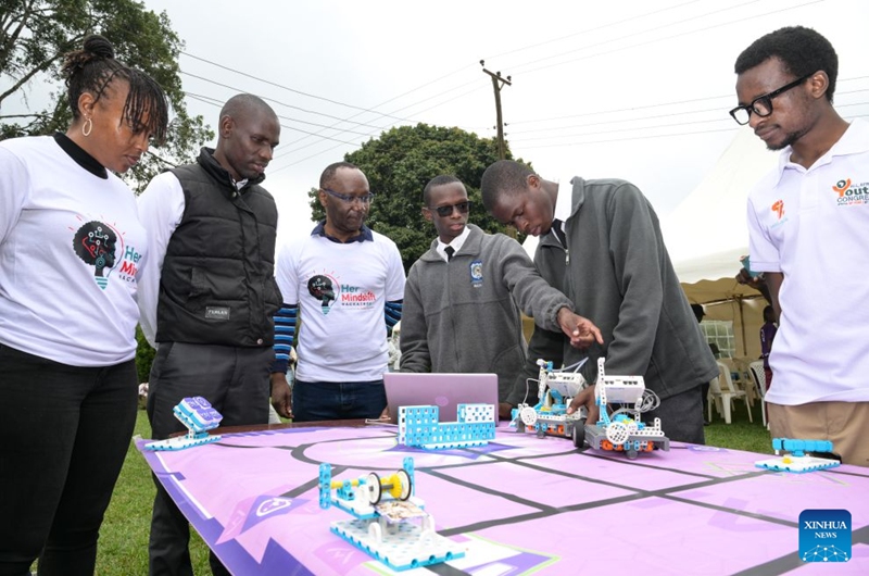 Students (2nd R and 3rd R) explain robot coding to people during an artificial intelligence (AI)-enabled coding and robotics competition in Kiambu county, central Kenya, July 17, 2026. More than 200 young learners participated in the competition here on Friday.(Xinhua/Yang Guang)