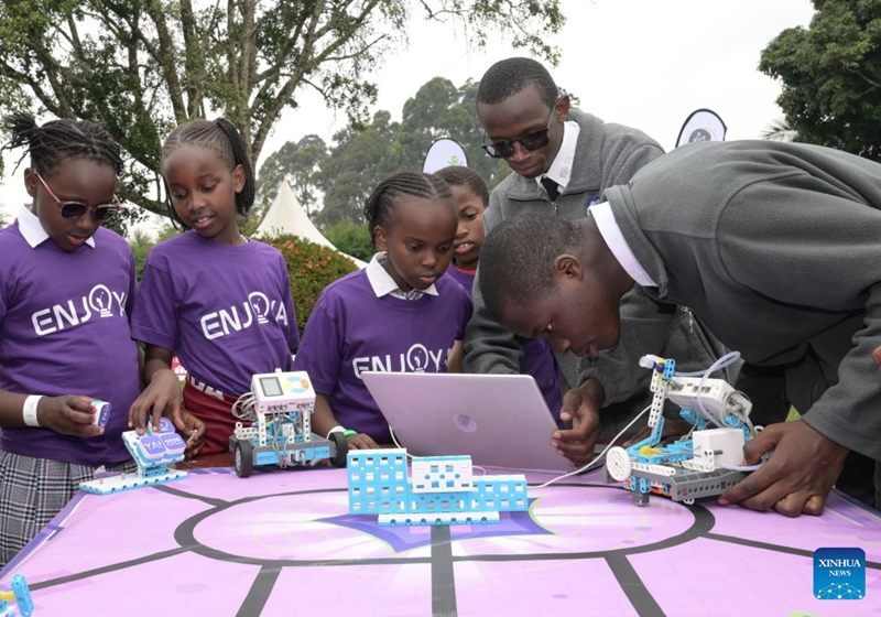 Students (1st R and 2nd R) demonstrate robot adjustment operations for primary school pupils during an artificial intelligence (AI)-enabled coding and robotics competition in Kiambu county, central Kenya, July 17, 2026. More than 200 young learners participated in the competition here on Friday.(Xinhua/Yang Guang)