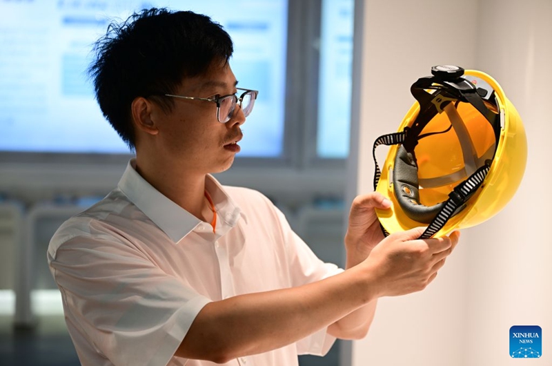 A staff member displays a brain-computer interface (BCI) helmet at an exhibition hall of Anhui North Microelectronics Research Institute Group Co., Ltd. in Bengbu, east China's Anhui Province, July 17, 2026. Bengbu, a traditional industrial city, has stepped up the development of its brain-computer interface (BCI) industry in recent years. By strengthening collaboration among industry, research institutes and medical institutions, Bengbu has built an innovation ecosystem that supports both BCI research and clinical application, aiming to become an emerging BCI innovation hub in the Yangtze River Delta region. Photo: Xinhua