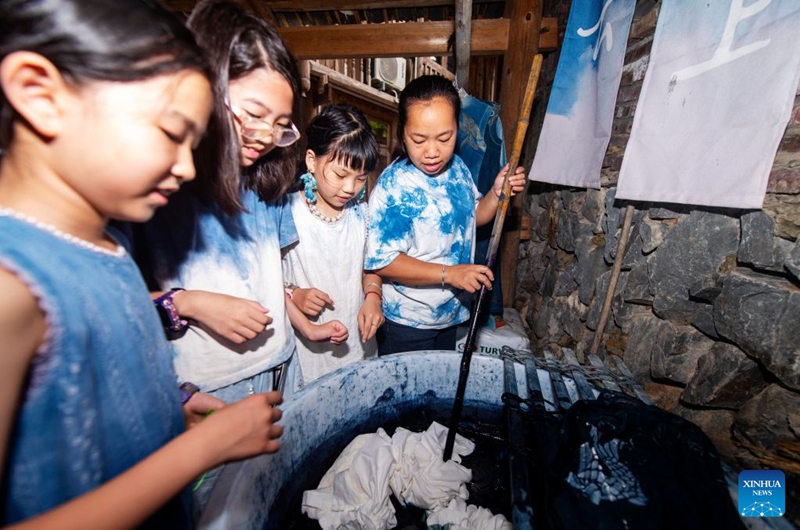Children from Shenzhen learn traditional indigo dyeing in Meide Village of Congjiang County, Qiandongnan Miao and Dong Autonomous Prefecture, southwest China's Guizhou Province, July 15, 2026. In the summer vacation, a surging number of students from big cities like Shanghai and Shenzhen come to Meide Village of Qiandongnan Miao and Dong Autonomous Prefecture for a study tour, living with local people and experiencing the culture and customs of the Dong ethnic group. Photo: Xinhua