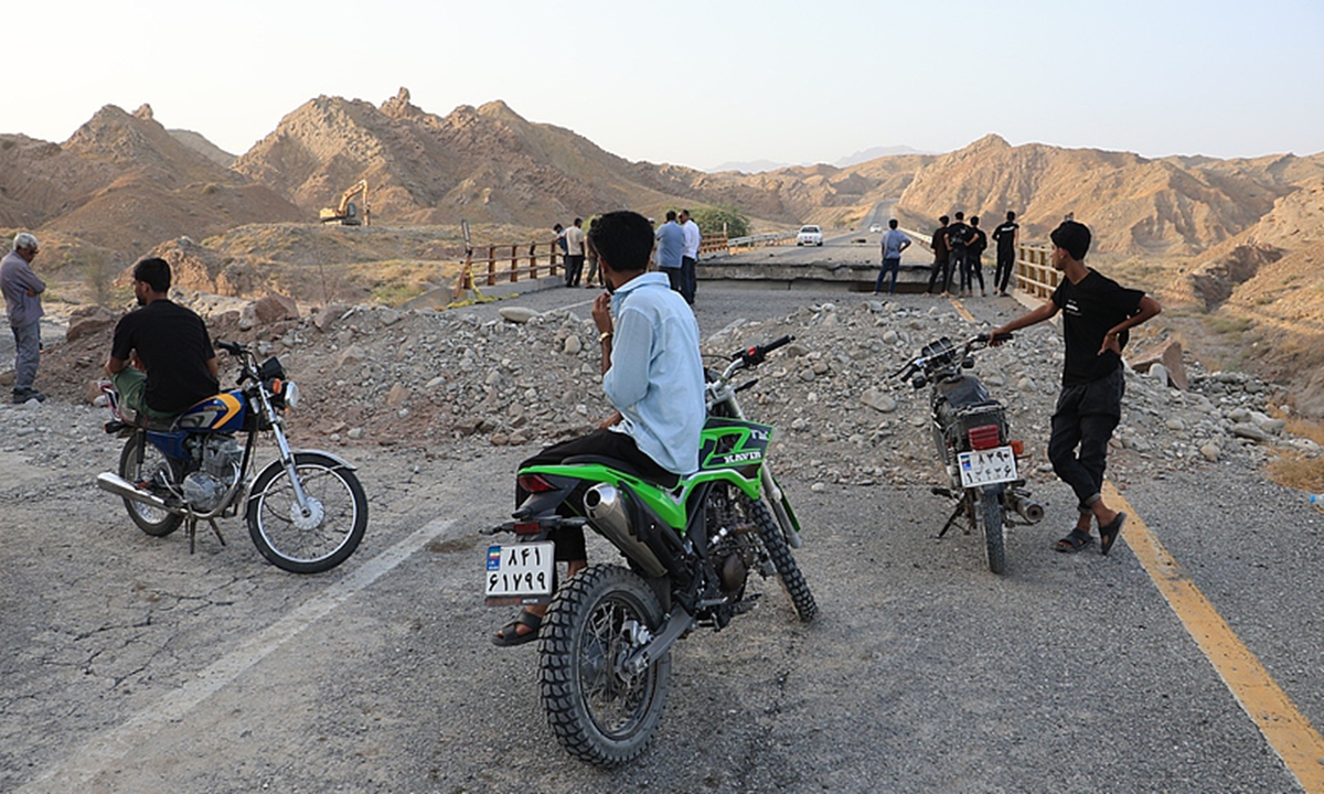 People stand on a bridge destroyed after a strike in Hormozgan province, southern Iran, Saturday, on July 18, 2026. Photo: VCG
