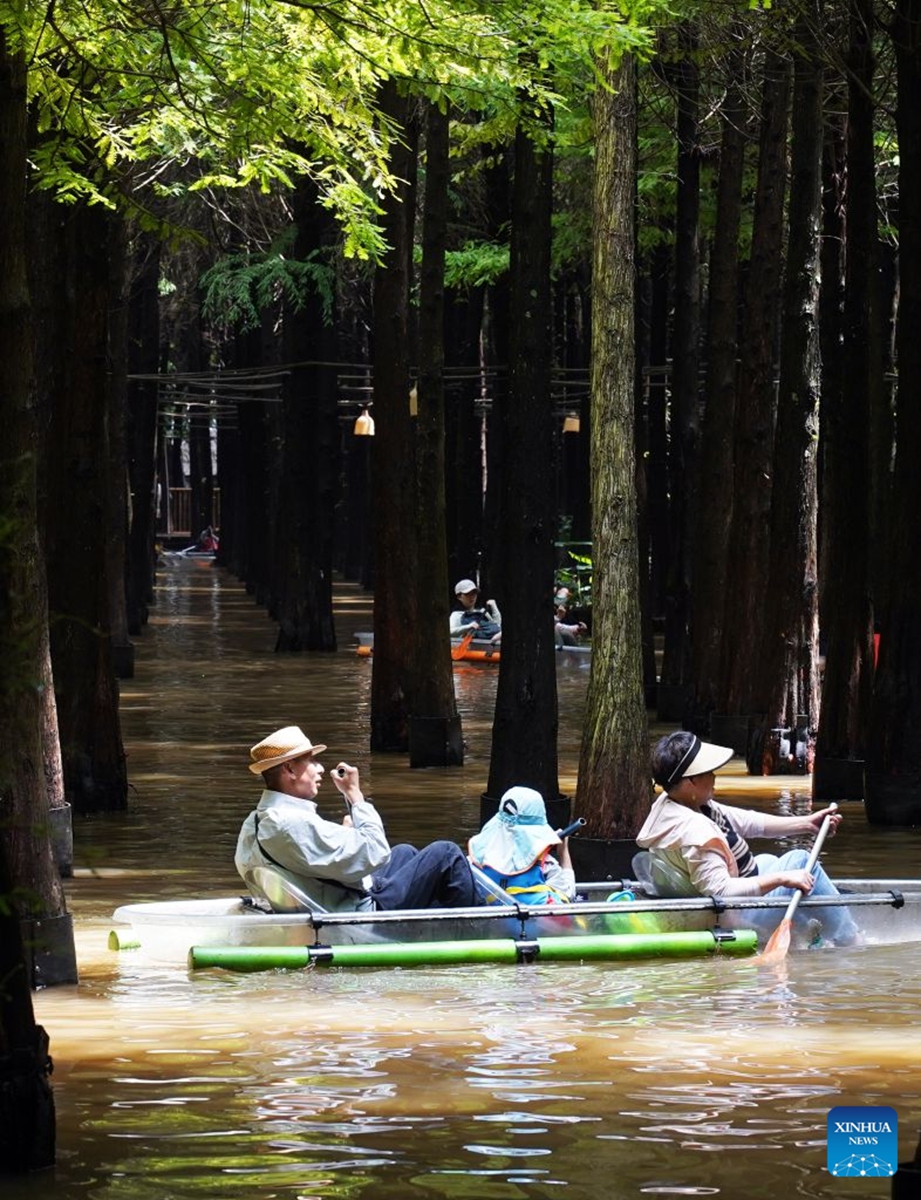 Tourists enjoy the scenery at a wetland park in Kunming City, southwest China's Yunnan Province, July 18, 2026. (Photo by Liang Zhiqiang/Xinhua)