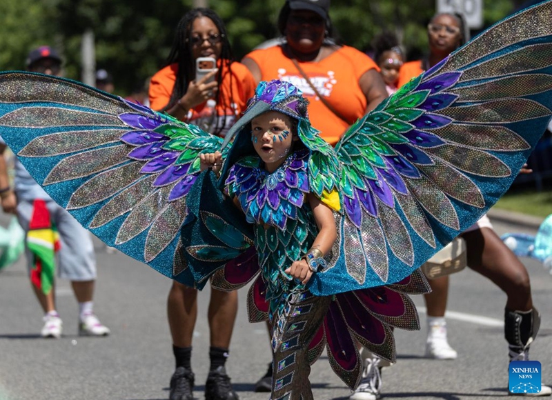 A dressed-up boy dances during the Junior Carnival Parade of the 2026 Toronto Caribbean Carnival in Toronto, Canada, on July 19, 2026. Thousands of young participants in vivid costumes took part in the parade, celebrating Caribbean culture through music and dance. (Photo by Zou Zheng/Xinhua)