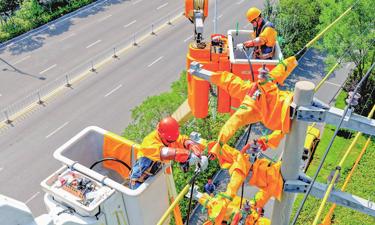 Staff members of Bozhou Power Supply Company of the State Grid carry out maintenance work in sweltering heat in Bozhou, East China's Anhui Province, on July 20, 2026. As persistent high temperatures push up power demand, the company has deployed service teams to strengthen line inspections to guarantee electricity supply. Photo: VCG