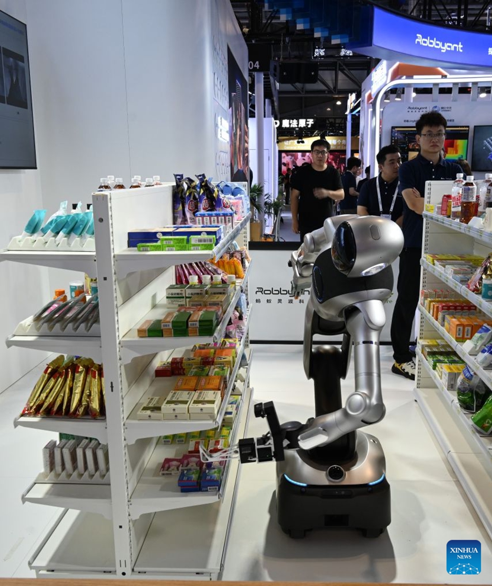 A robot fetches a pack of mock medicine from a shelf during the 2026 World AI Conference in Shanghai, east China, July 19, 2026. The ongoing 2026 World AI Conference turns out to be a highly competitive arena for general embodied AI products from more than 200 providers. It refers to a general-purpose intelligence system that enables robots to perform variable tasks and adapt to different application scenarios. (Xinhua/Huang Xiaoyong)