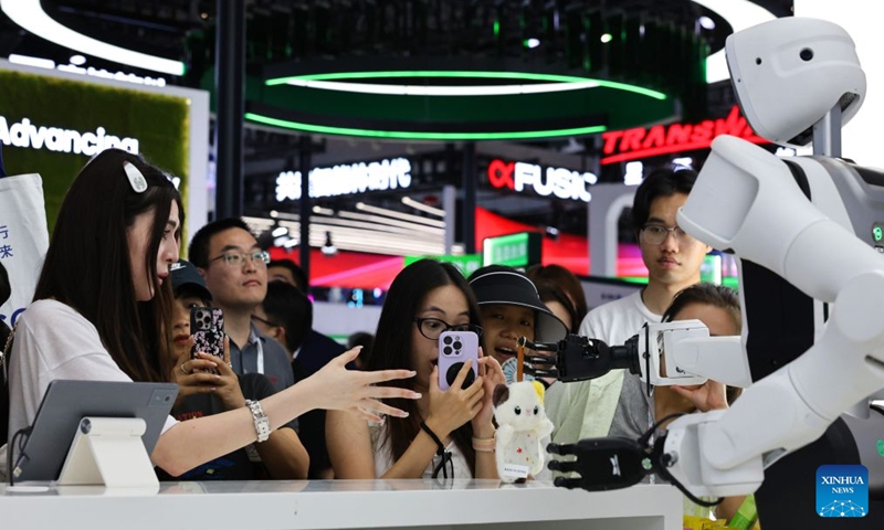 Visitors experience services provided by a robot during the 2026 World AI Conference and High-Level Meeting on Global AI Governance in Shanghai, east China, July 19, 2026. The event scheduled from Friday to Monday showcases exhibitions of a number of AI agent hardware and system products, highlighting the transition of next-generation AI from a tool to an intelligent partner, empowering various industries and everyday life. (Xinhua/Fang Zhe)