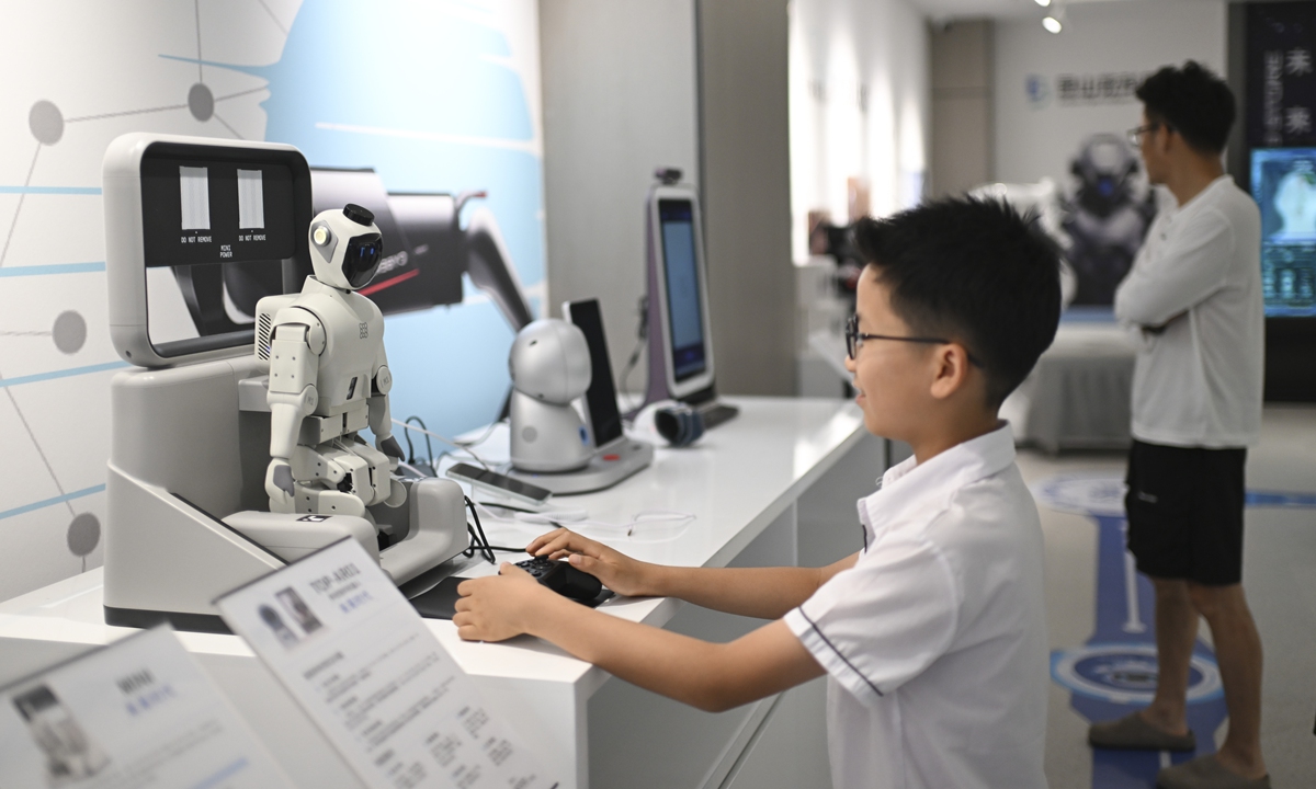 A child tries out a robot at the world's first robot 6S store in Kunshan, East China's Jiangsu Province, on July 20, 2026. The store offers six themed sections, including robot interaction, industry scenario experiences, Kunshan-made intelligent products, humanoid robots, drones and AI-powered toys. Photo: VCG