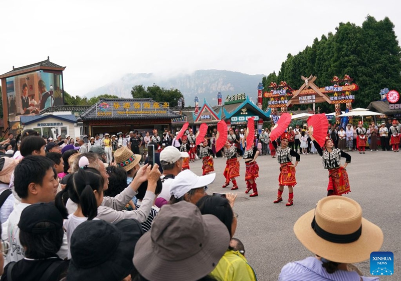 Tourists watch a dance performance at a scenic area in Kunming City, southwest China's Yunnan Province, July 18, 2026. (Photo by Liang Zhiqiang/Xinhua)