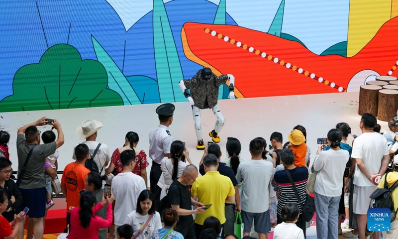 People watch a robot performing at the Haikou International Duty Free Shopping Complex in Haikou, south China's Hainan Province, July 18, 2026. Hainan is experiencing a surge in duty-free shopping during this summer season. It is reported that in the first six months of this year, offshore duty-free sales totaled 19.92 billion yuan (about 2.93 billion U.S. dollars), involving 15.966 million duty-free items and 2.793 million shoppers, registering year-on-year growth of 18.8%, 7.3% and 12.6% respectively. (Xinhua/Yang Guanyu)