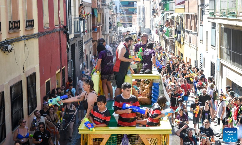 People participate in the Batalla Naval de Vallecas, a water fight festival, in Madrid, Spain, on July 19, 2026. (Photo by Gustavo Valiente/Xinhua)