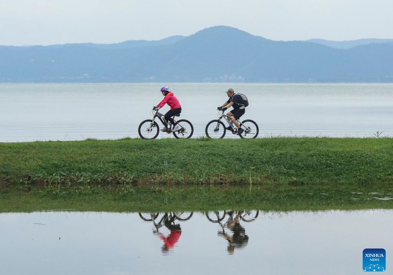 Tourists ride bicycles at a wetland park in Kunming City, southwest China's Yunnan Province, July 19, 2026. (Photo by Zheng Yi/Xinhua)
