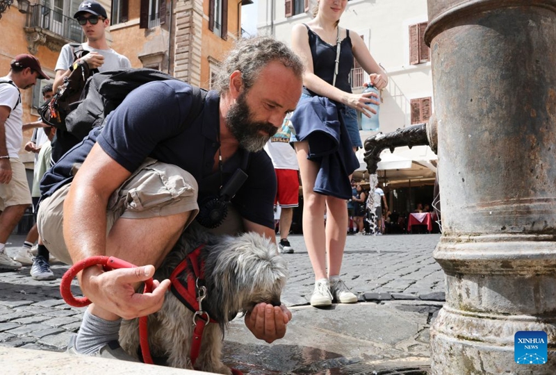 A man feeds his dog some water at a nasoni, Rome's drinking fountain in Rome, Italy, July 19, 2026. A new heatwave is sweeping Italy, with many major cities, including the capital Rome, under red heat alerts. The scorching conditions are forecast to last until next week. Photo: Xinhua