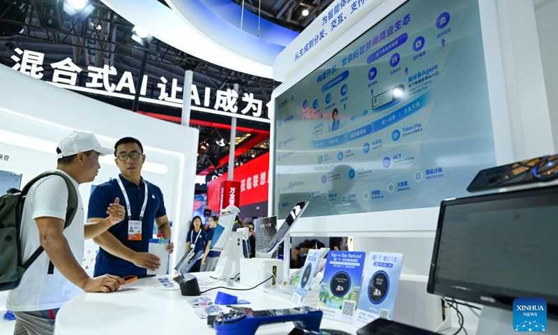 A staff member (R) introduces the agent business ecosystem to a visitor at the booth of Ant Group during the 2026 World AI Conference and High-Level Meeting on Global AI Governance in Shanghai, east China, July 19, 2026. The event scheduled from Friday to Monday showcases exhibitions of a number of AI agent hardware and system products, highlighting the transition of next-generation AI from a tool to an intelligent partner, empowering various industries and everyday life. (Xinhua/Chen Haoming)