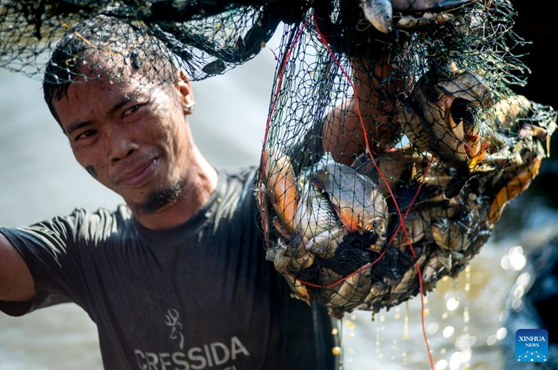 A man presents fish he caught during Festival Memet Ikan, or fish catching festival, at Gemblegan village in Klaten regency, Central Java, Indonesia, July 19, 2026. (Photo by Agung Supriyanto/Xinhua)