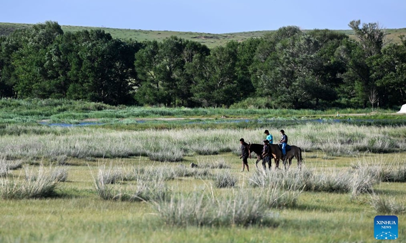 Tourists ride horses at the Xilingol grassland in north China's Inner Mongolia Autonomous Region, July 19, 2026. (Xinhua/Li Zhipeng)