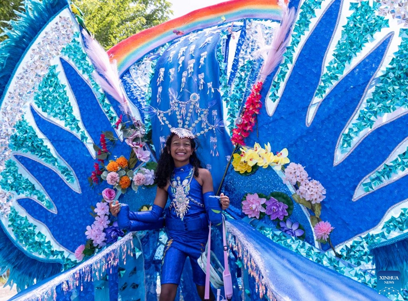 A dressed-up girl with her float is pictured during the Junior Carnival Parade of the 2026 Toronto Caribbean Carnival in Toronto, Canada, on July 19, 2026. Thousands of young participants in vivid costumes took part in the parade, celebrating Caribbean culture through music and dance. (Photo by Zou Zheng/Xinhua)