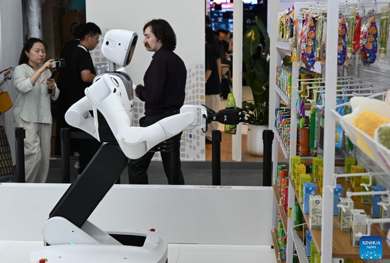 A robot fetches a bottled beverage from a shelf during the 2026 World AI Conference in Shanghai, east China, July 19, 2026. The ongoing 2026 World AI Conference turns out to be a highly competitive arena for general embodied AI products from more than 200 providers. It refers to a general-purpose intelligence system that enables robots to perform variable tasks and adapt to different application scenarios. (Xinhua/Huang Xiaoyong)