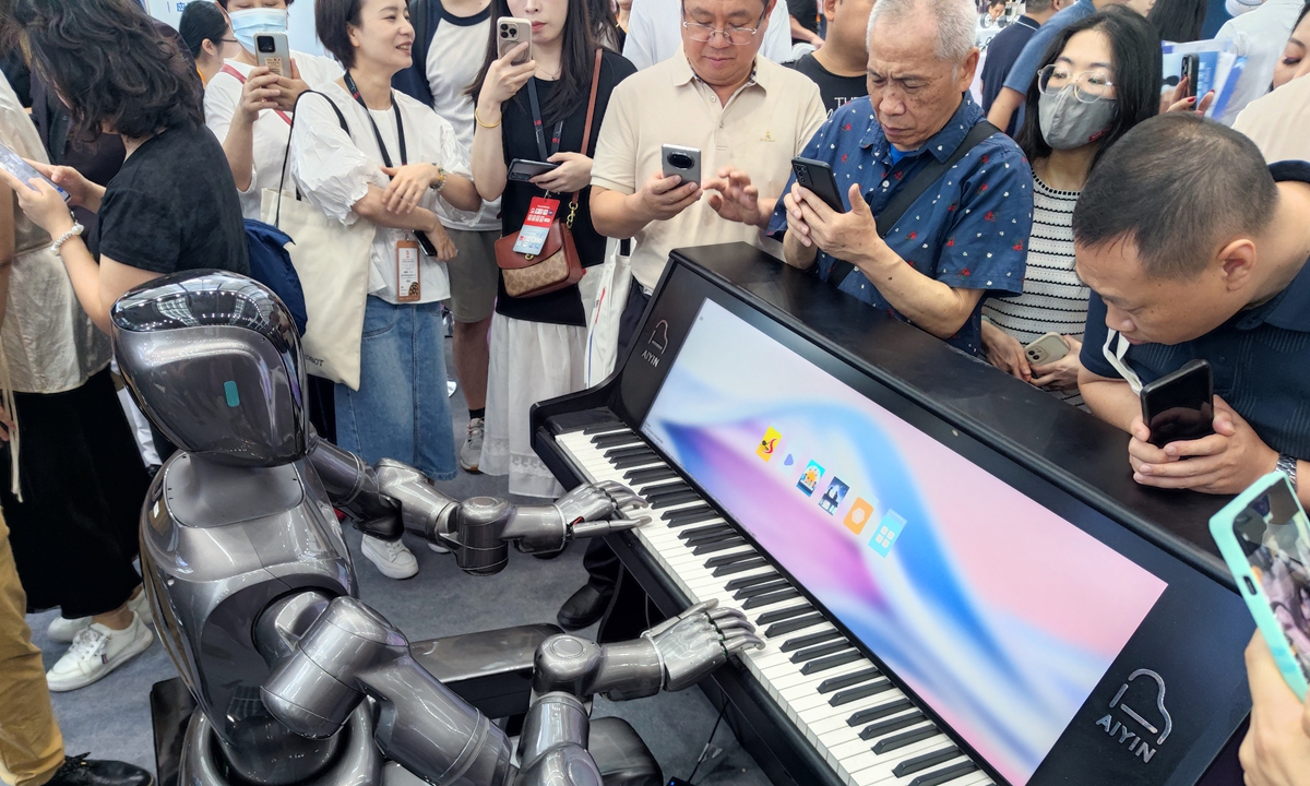People watch a humanoid robot play the piano in Shenzhen, South China's Guangdong Province. Photos: VCG