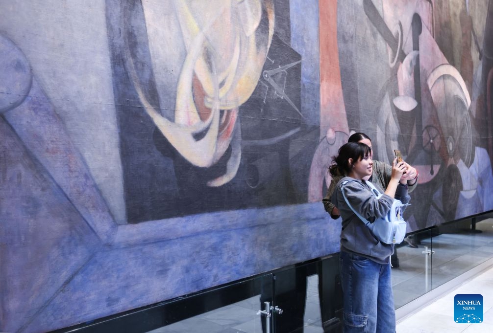 Visitors take photos with Diego Rivera's paintings at the Museum of Palacio de Bellas Artes, in Mexico City, Mexico, on July 19, 2026. The museum offers free admission on Sundays, attracting large numbers of residents and tourists to explore its exhibitions. (Xinhua/Liu Wenhui)