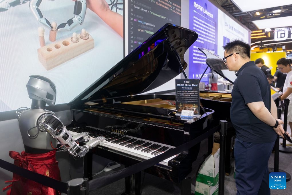 A visitor watches a robot playing the piano during the 2026 World AI Conference and High-Level Meeting on Global AI Governance in Shanghai, east China, July 20, 2026. The 2026 World AI Conference and High-Level Meeting on Global AI Governance concluded here on Monday. (Xinhua/Wang Xiang)