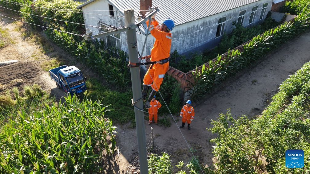 An aerial drone photo taken on July 20, 2026 shows staff members inspecting power lines for electricity restoration in Ning'an Township of Ning'an City, Mudanjiang, northeast China's Heilongjiang Province. Water supply and power departments in Mudanjiang have stepped up efforts to restore water and electricity services in the affected areas as flooding gradually recedes in the city. (Photo by Zhang Chunxiang/Xinhua)