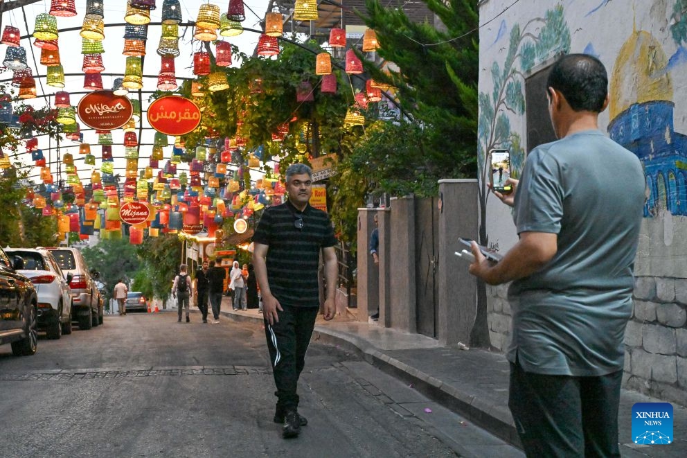 A man poses for a photo at the Rainbow Street in Amman, Jordan, on July 20, 2026. Amman is the capital of Jordan where tradition and modernity coexist. From the ancient Citadel to the modern shopping district, traces of different eras intertwine to reveal the city's unique charm and enduring vitality. (Xinhua/Xin Mengchen)