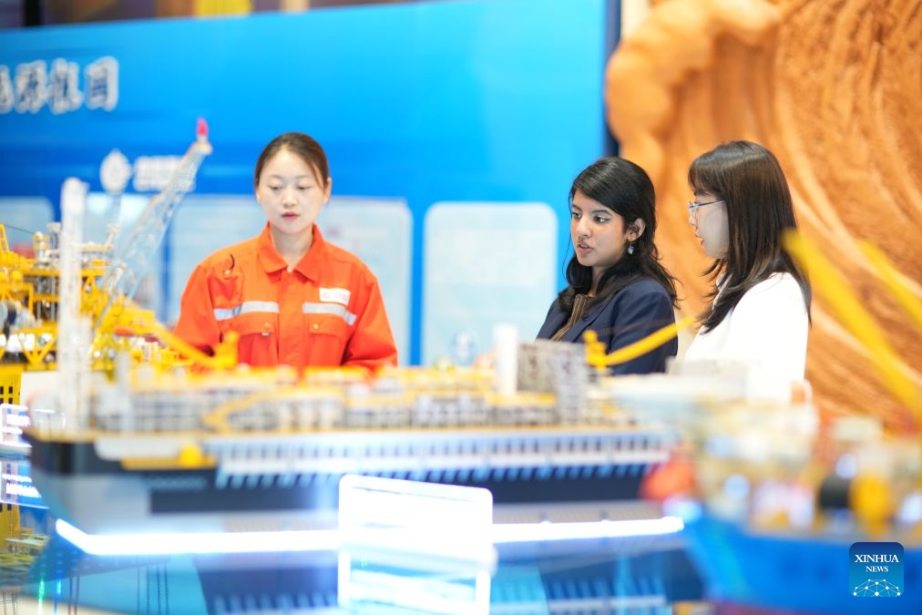 Rimaz Dakhilallah Aljohani (C) views an engineering model at the Tianjin Intelligent Manufacturing Branch of Offshore Oil Engineering Co., Ltd. (COOEC) in Tianjin, north China, July 9, 2026. (Photo by Li Haowei/Xinhua)