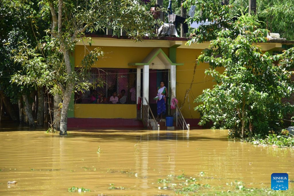 Villagers stay at a house besieged by floodwaters after heavy rains in Jorhat district of India's northeastern state of Assam, on July 21, 2026. (Str/Xinhua)