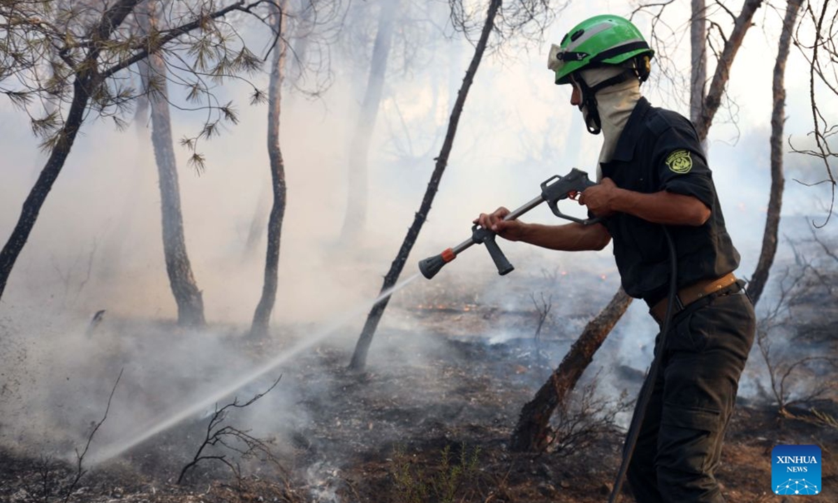 A firefighter works to put out a wildfire on a mountain in El Hachimia, northern Algeria, on July 21, 2026. Six people have been killed in wildfires sweeping across northern Algeria as a prolonged heat wave continues to fuel forest and vegetation fires in several provinces, the Algerian Ministry of the Interior, Local Authorities and Transports said Tuesday. (Photo by Billel Bensalem/Xinhua)