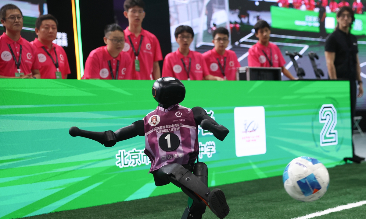 A humanoid robot kicks a ball during the final match of the inaugural Beijing middle school humanoid robot football tournament, hosted by Tsinghua University on July 22, 2026. Centered on humanoid robot football competition as a hands-on practical medium, this event serves as a platform to cultivate students' scientific literacy and engineering practice capabilities. Photo: VCG