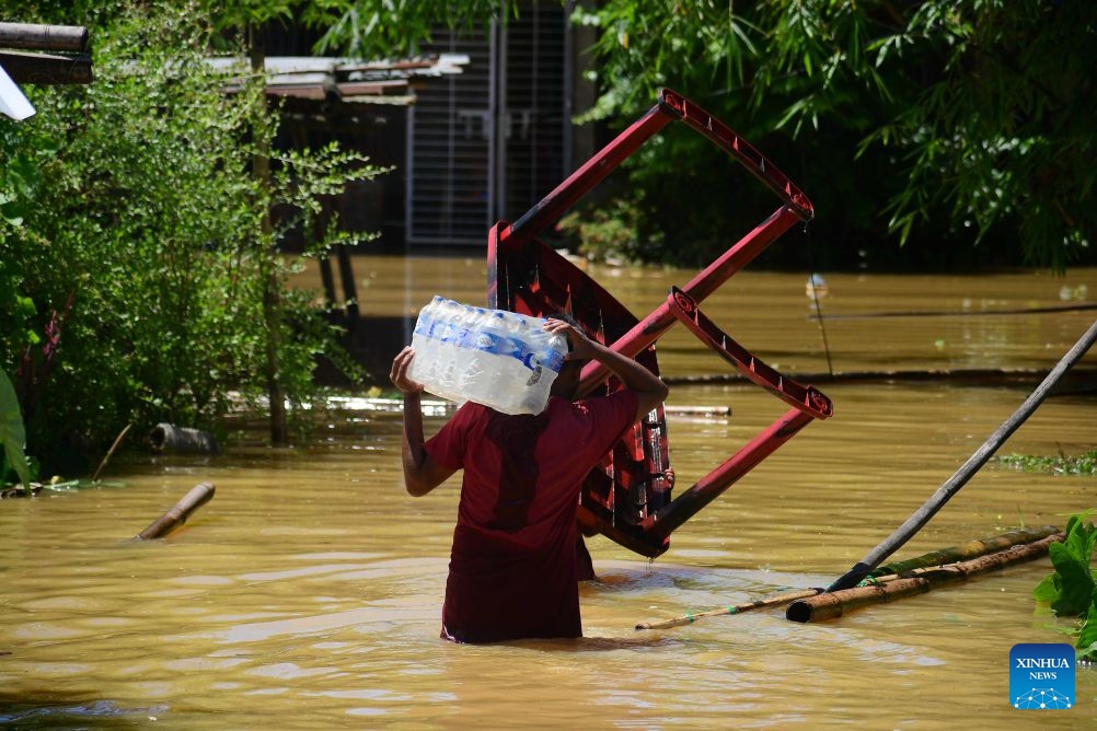 A villager wades through floodwaters after heavy rains in Jorhat district of India's northeastern state of Assam, on July 21, 2026. (Str/Xinhua)