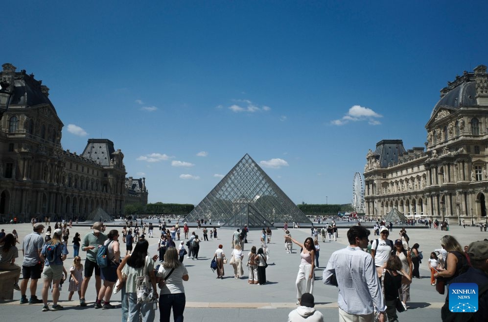 Tourists are pictured near the Louvre Museum in Paris, France, July 21, 2026. The Apollo Gallery at the Louvre Museum, which was robbed in October 2025, is set to reopen to the public on Wednesday, with no jewelry to be displayed, French media reported on Monday. (Xinhua/Wu Huiwo)