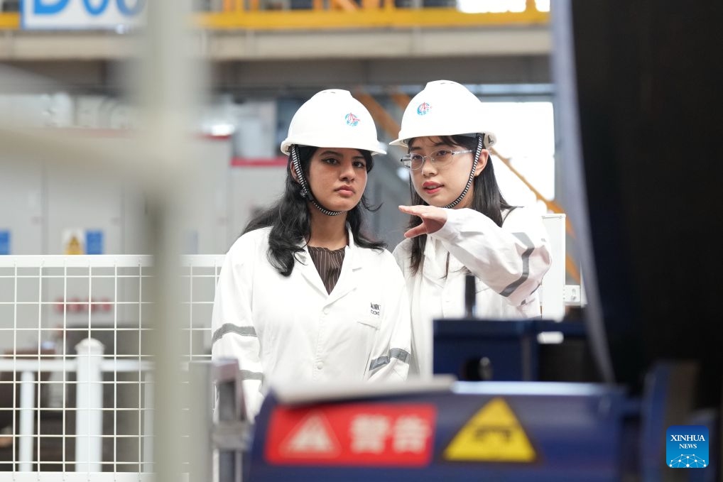 Rimaz Dakhilallah Aljohani (L) learns about an intelligent welding device at the Tianjin Intelligent Manufacturing Branch of Offshore Oil Engineering Co., Ltd. (COOEC) in Tianjin, north China, July 9, 2026. (Photo by Li Haowei/Xinhua)