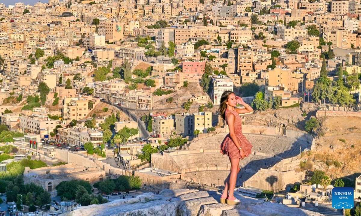 A tourist poses for a photo at the Citadel in Amman, Jordan, on July 20, 2026. Amman is the capital of Jordan where tradition and modernity coexist. From the ancient Citadel to the modern shopping district, traces of different eras intertwine to reveal the city's unique charm and enduring vitality. (Xinhua/Xin Mengchen)