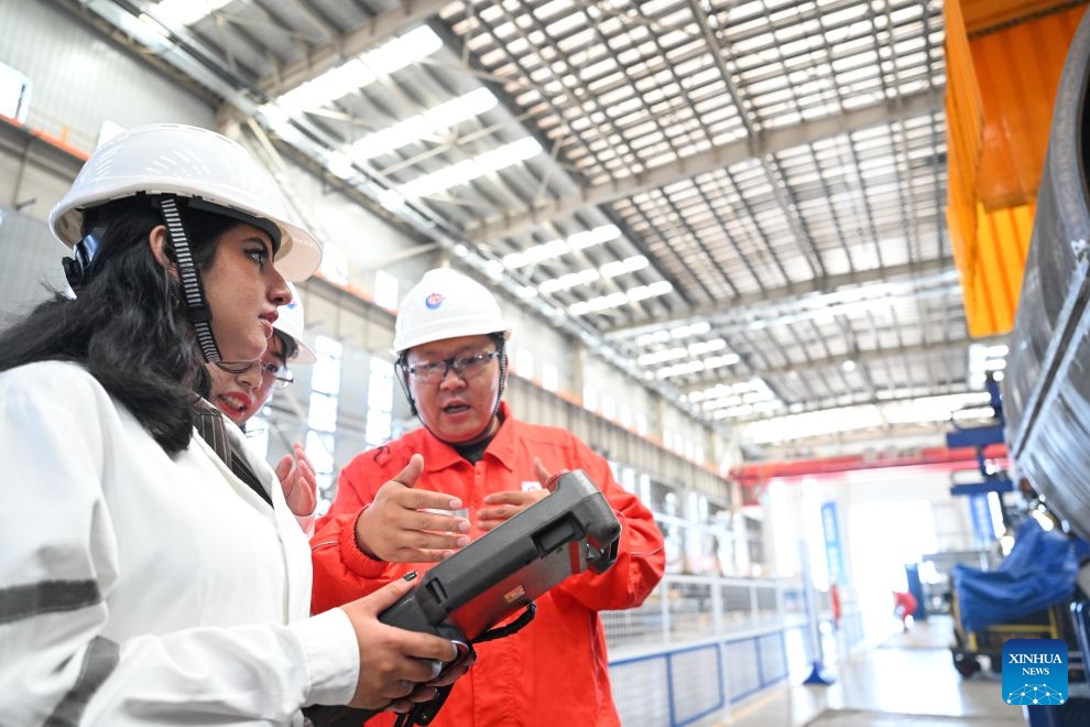 Rimaz Dakhilallah Aljohani (L) tries the teaching pendant of an intelligent welding device at the Tianjin Intelligent Manufacturing Branch of Offshore Oil Engineering Co., Ltd. (COOEC) in Tianjin, north China, July 9, 2026. (Xinhua/Zhao Zishuo)