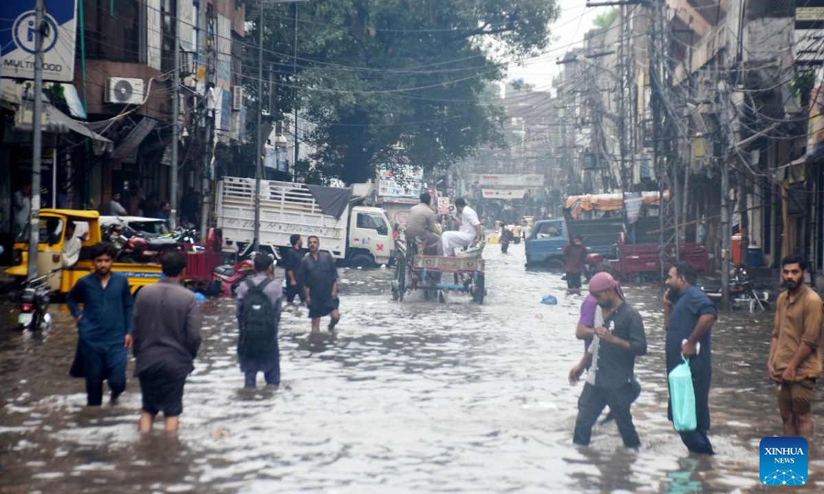 People wade through a flooded street after heavy monsoon rains in Lahore, Pakistan, July 22, 2026. At least eight people were killed and 16 others injured in rain-related incidents across Pakistan over the past 24 hours as monsoon showers continued to batter parts of the country, the National Disaster Management Authority said on Tuesday. (Photo by Sajjad/Xinhua)