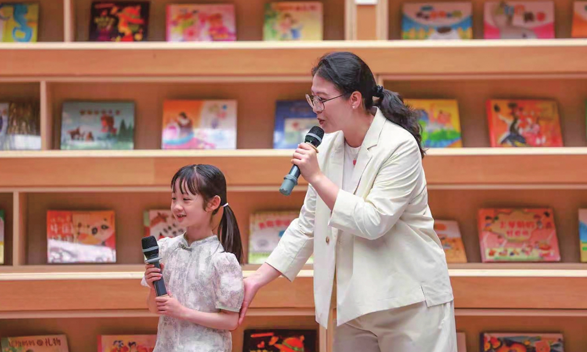 Chen Mulan engages with a girl at a reading promotion event in Central China's Hubei Province.