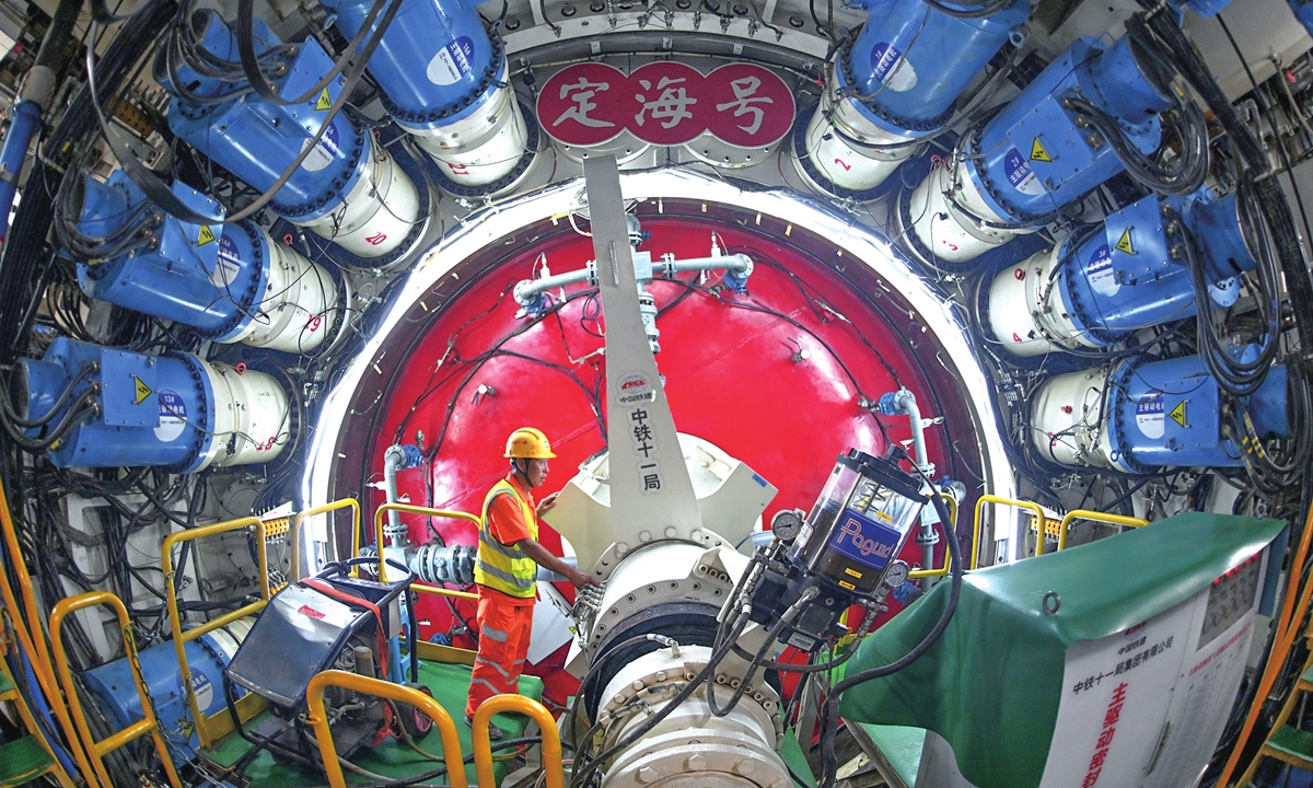 A worker inspects the main drive system of a tunnel boring machine on July 23, 2026. On that day, China Railway 11th Bureau Group's world-first