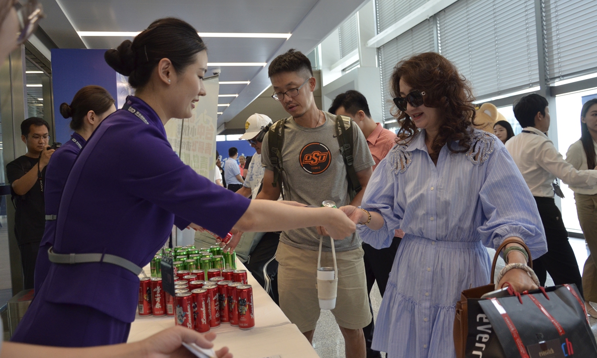 Staff at the Qingdao Airport in East China's Shandong Province hand out local gifts to passengers aboard the maiden return flight linking Qingdao and Taichung in central Taiwan region on July 23, 2026. Operated by Shandong Airlines, the direct air route officially resumed service the same day, with weekly Thursday flights scheduled. Photo: VCG