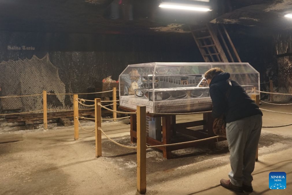 Visitors get a close-up view of a full-scale model of a defunct salt mine's facilities in Turda, Romania, on July 23, 2026. As a new heat wave sweeps across Europe, the defunct salt mine in Turda has become a popular retreat for visitors seeking to escape the summer heat.

Featuring recreational facilities such as rowboats, a Ferris wheel and billiard tables, the salt mine maintains a year-round temperature of around 10 to 12 degrees Celsius. (Xinhua/Yao Yulin)