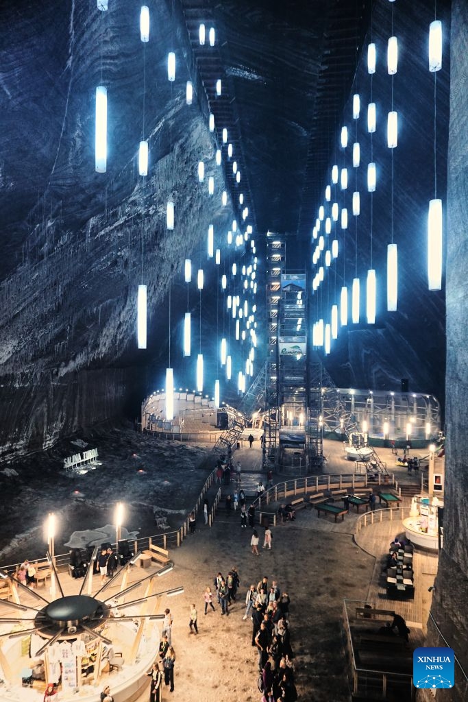 This photo taken on July 23, 2026 shows a view of a defunct salt mine in Turda, Romania. As a new heat wave sweeps across Europe, the defunct salt mine in Turda has become a popular retreat for visitors seeking to escape the summer heat.
Featuring recreational facilities such as rowboats, a Ferris wheel and billiard tables, the salt mine maintains a year-round temperature of around 10 to 12 degrees Celsius. (Xinhua/Yao Yulin)
