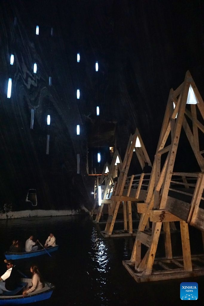 Visitors row boats in an underground lake at a defunct salt mine in Turda, Romania, on July 23, 2026. As a new heat wave sweeps across Europe, the defunct salt mine in Turda has become a popular retreat for visitors seeking to escape the summer heat.

Featuring recreational facilities such as rowboats, a Ferris wheel and billiard tables, the salt mine maintains a year-round temperature of around 10 to 12 degrees Celsius. (Xinhua/Yao Yulin)