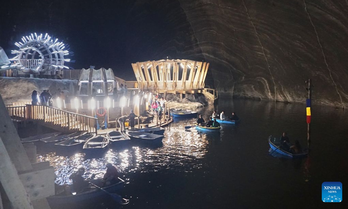 Visitors row boats in an underground lake at a defunct salt mine in Turda, Romania, on July 23, 2026. As a new heat wave sweeps across Europe, the defunct salt mine in Turda has become a popular retreat for visitors seeking to escape the summer heat.
Featuring recreational facilities such as rowboats, a Ferris wheel and billiard tables, the salt mine maintains a year-round temperature of around 10 to 12 degrees Celsius. (Xinhua/Yao Yulin)