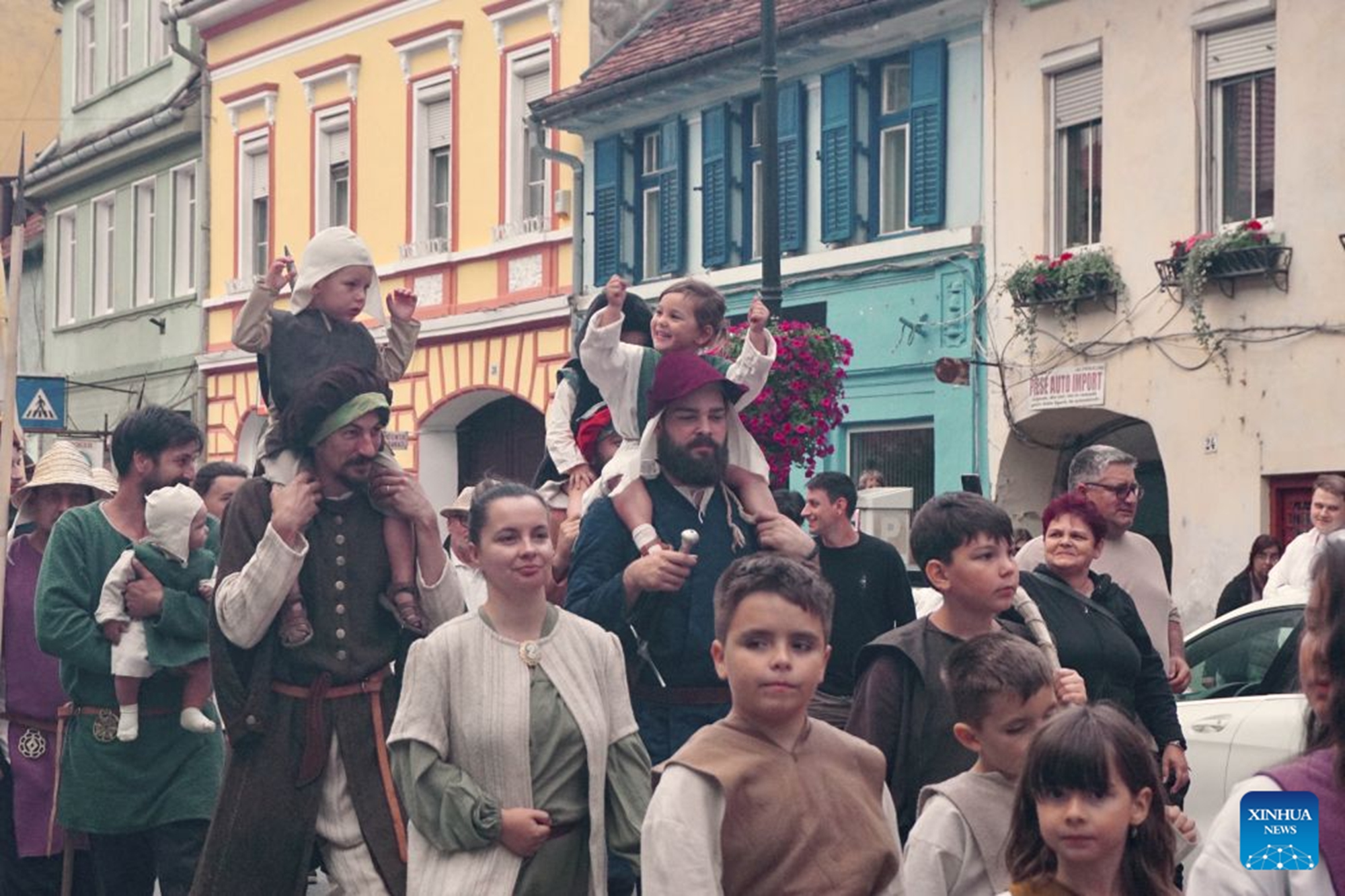 Local residents attend a parade during the Sighisoara Medieval Festival in Sighisoara, Romania, July 24, 2026. The annual Sighisoara Medieval Festival kicked off here on Friday and will last until Sunday. First launched in 1992, the festival is now a distinctive historical celebration in Europe, which revives medieval culture and traditions through various activities. The historic center of Sighisoara was inscribed as a UNESCO World Heritage in 1999. (Xinhua/Yao Yulin)