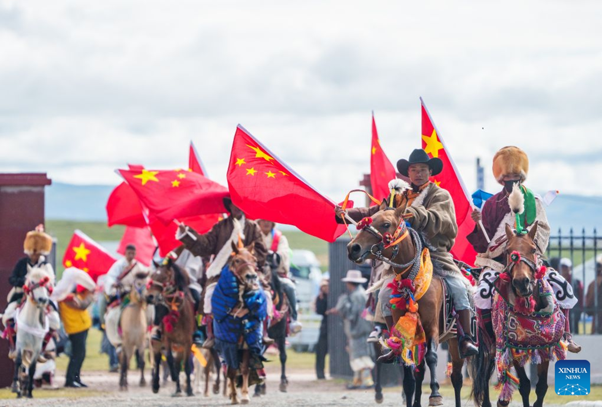 Riders enter the venue of a horse racing competition in Amdo County, southwest China's Xizang Autonomous Region, July 23, 2026. The horse racing competition kicked off here on Thursday, featuring vibrant performances and horse racing events. (Xinhua/Tenzin Nyida)