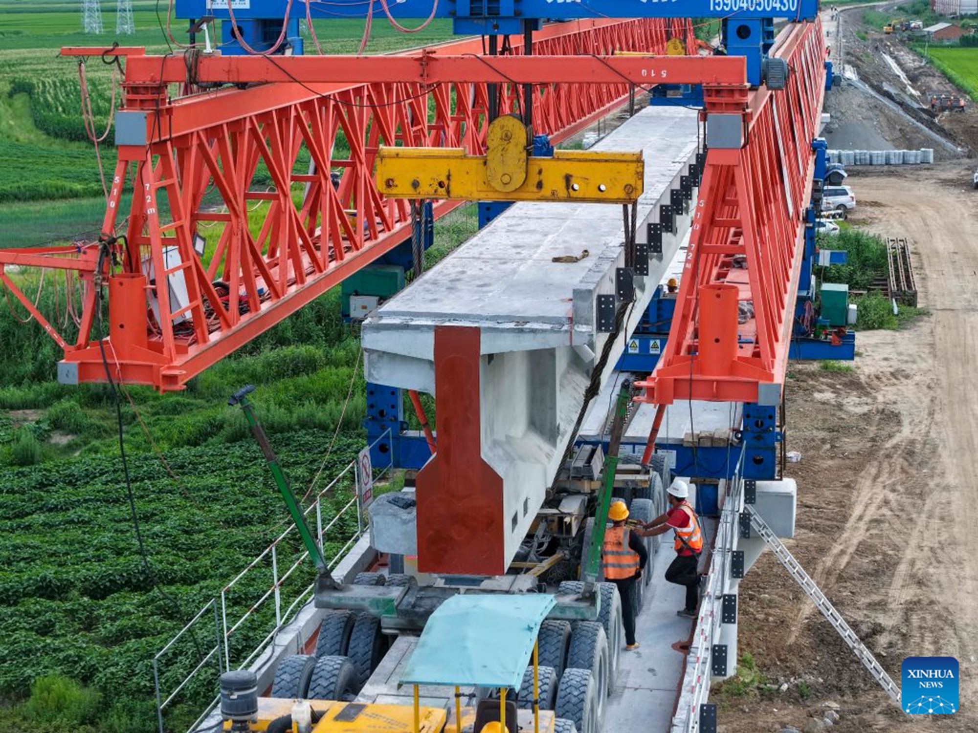 A drone photo taken on July 23, 2026 shows staff members working at the construction site of the Tongjiang super major bridge in northeast China's Heilongjiang Province.(Xinhua/Wang Song)