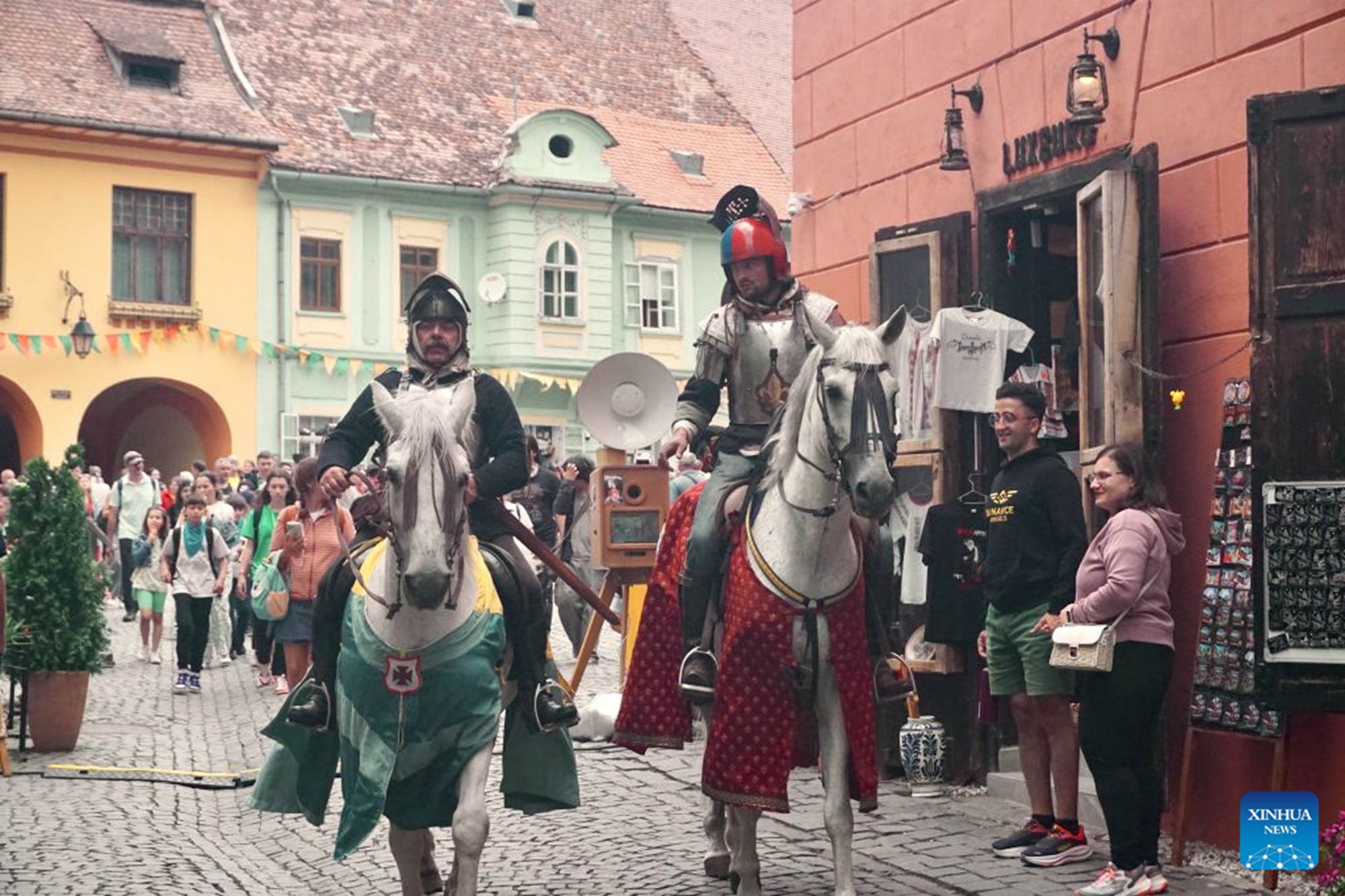 Local residents attend a parade during the Sighisoara Medieval Festival in Sighisoara, Romania, July 24, 2026. The annual Sighisoara Medieval Festival kicked off here on Friday and will last until Sunday. First launched in 1992, the festival is now a distinctive historical celebration in Europe, which revives medieval culture and traditions through various activities. The historic center of Sighisoara was inscribed as a UNESCO World Heritage in 1999. (Xinhua/Yao Yulin)