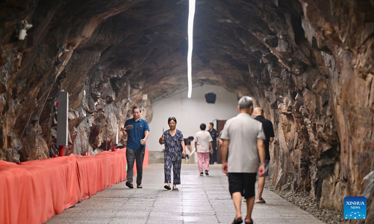 Residents relax at an air-raid shelter to cool off in Fuzhou, southeast China's Fujian Province, July 23, 2026. As summer temperatures soar, Fuzhou has made some tunnels, air-raid shelters and metro stations available as public cooling spaces. Equipped with benches, chairs and other convenience facilities, these sites have become popular for residents to relax and escape the heat. (Xinhua/Jiang Kehong)