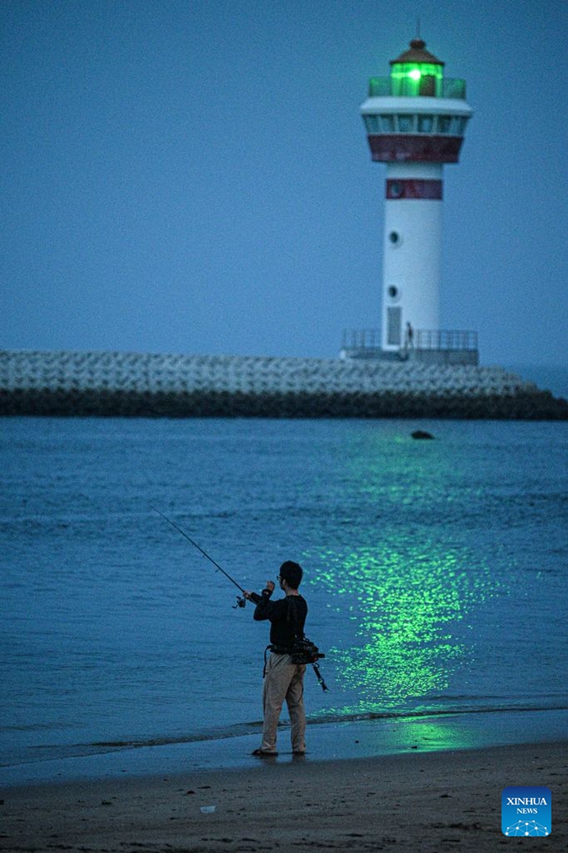 A tourists fishes at Paigang Village of Tanmen Town in Qionghai City, south China's Hainan Province, July 21, 2026. Building on the unique identities of Boao Town, home to the Boao Forum for Asia, and Tanmen Town, a historic fishing port with a thousand-year legacy, Qionghai City has been advancing the coordinated construction of picturesque rural villages across the Boao-Tanmen area. Taking advantage of Hainan's round-the-island highway, the city has linked both newly constructed and previously cultivated beautiful and harmonious villages into a cohesive chain to forge a globally influential rural revitalization belt. Photo: Xinhua