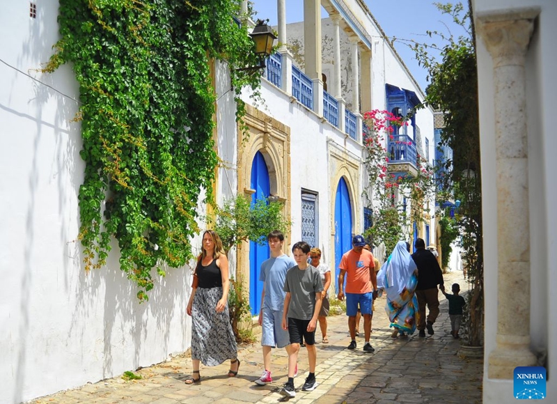 Visitors walk on an alley in the blue and white village of Sidi Bou Said, north of Tunisia, July 25, 2026. Tunisia's iconic village of Sidi Bou Said has been inscribed on the UNESCO World Heritage List, the country's Ministry of Cultural Affairs said on Saturday. (Photo by Adel Ezzine/Xinhua)